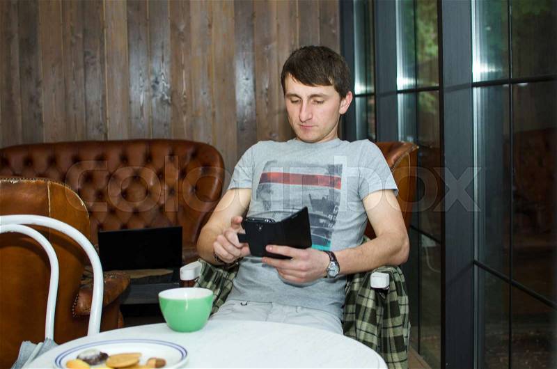 Young man using his black cell phone , stock photo