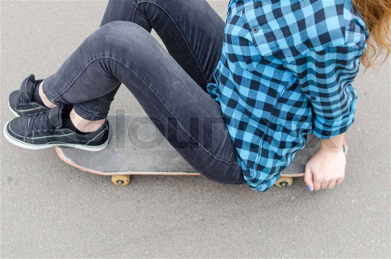 Young woman with the skateboard in the park, stock photo