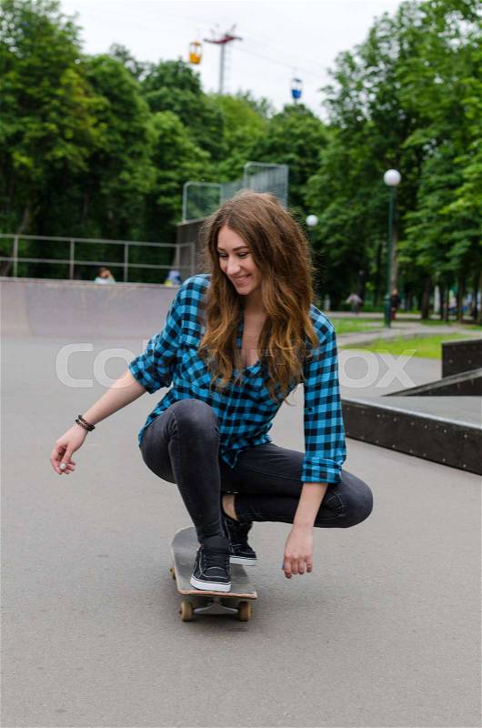 Young woman with the skateboard in the park, stock photo