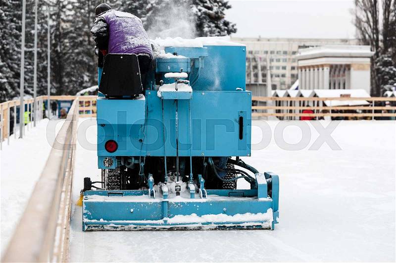 Special machine cleaning large amount of snow at ice skate rink.Winter holidays concept, stock photo