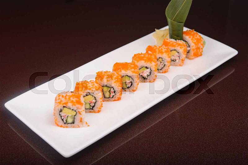Sushi rolls on a white plate, japanese food, glass dark background, stock photo
