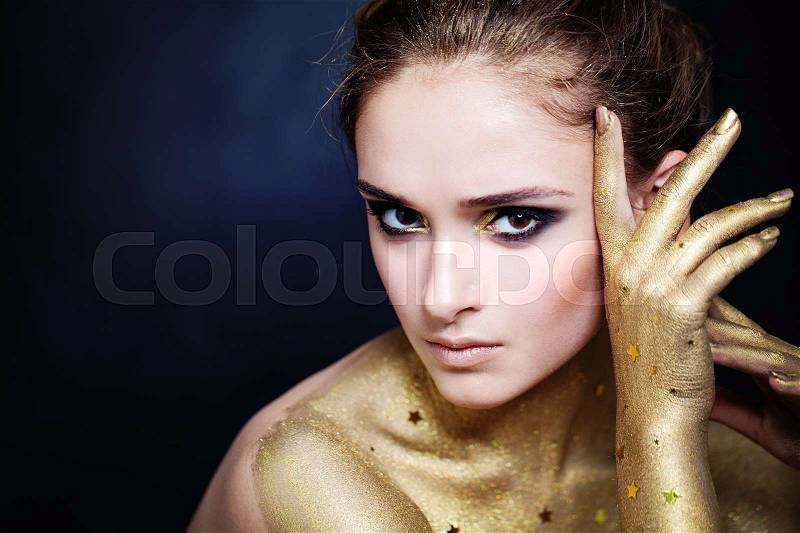 Elegant Woman with Golden Skin and Glamorous Party Makeup, stock photo