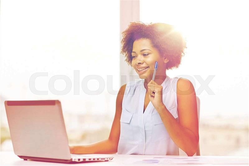 Education, business and technology concept - happy african american businesswoman or student with laptop computer and papers at office, stock photo