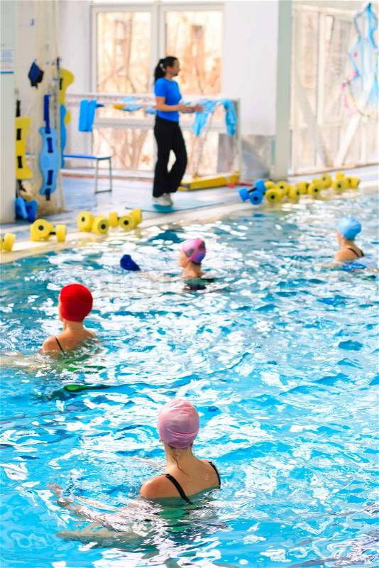 Coach teaches aqua aerobics in the pool, stock photo