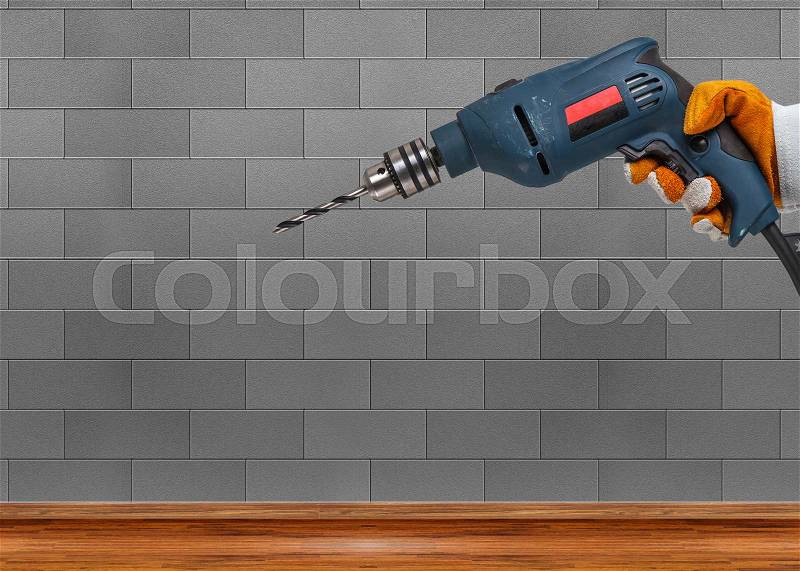 Builder or worker drilling with a machine or drill, stock photo