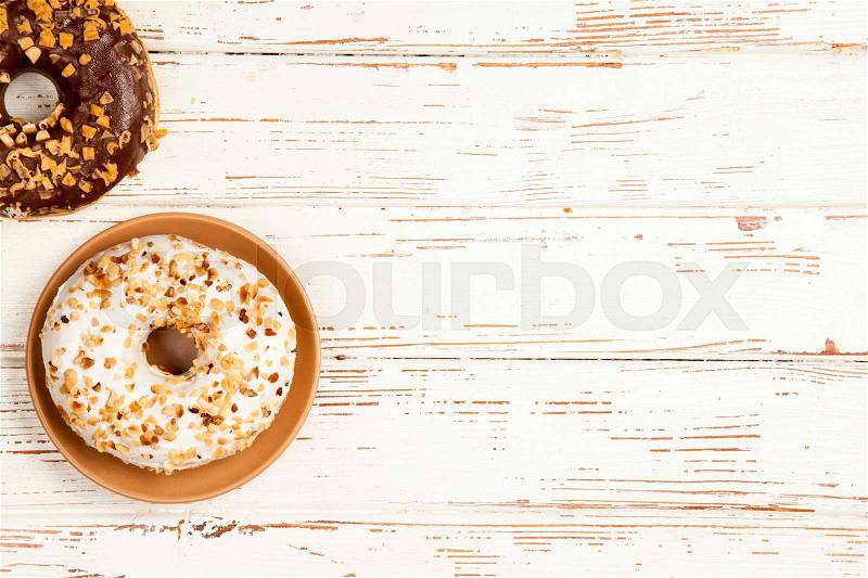 DIfferent tasty donuts on white wood background, stock photo