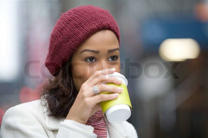 An attractive business woman enjoying a hot coffee in the city, stock photo