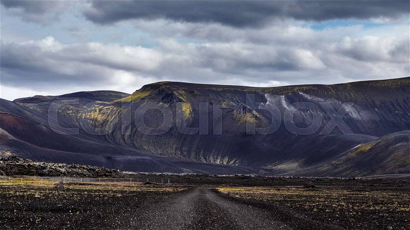Road on black sand in Iceland on mount background. Dramatic black landscape in Iceland, stock photo
