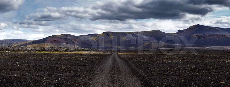 Panoramic view Road on black sand in Iceland on mount background. Dramatic black landscape in Iceland, stock photo
