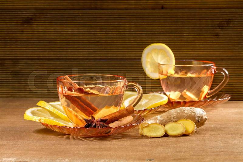 A cup of ginger tea with lemon, cinnamon and anise stars. Ginger tea on wooden background, stock photo