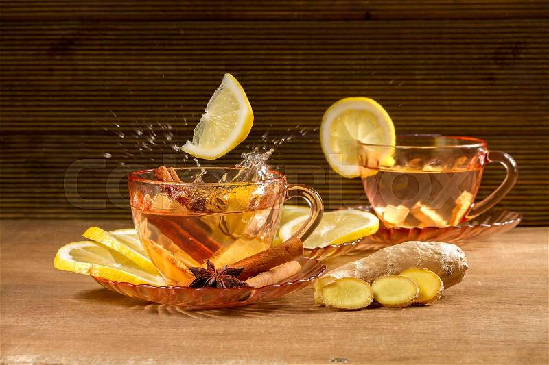 A cup of ginger tea with lemon, cinnamon and anise stars. Ginger tea on wooden background, stock photo