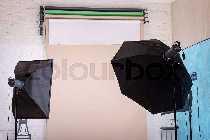 Empty photo studio with lighting equipment and paper background ready for photoshoot, stock photo