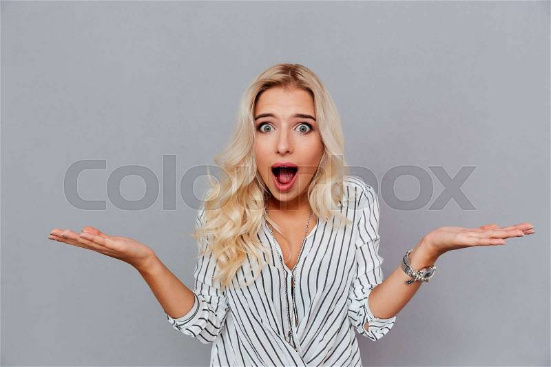 Portrait of surprised woman with mouth open standing isolated on a white background, stock photo