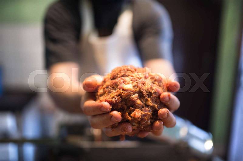 Unrecognizable man making sausages the traditional way at home. Holding meat ball in his hands, close up, stock photo
