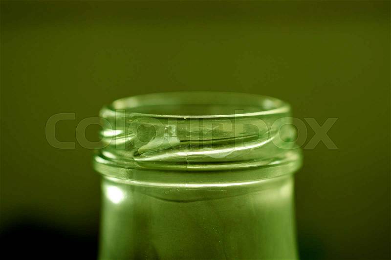 Returnable milk bottle glass closeup against green background, stock photo