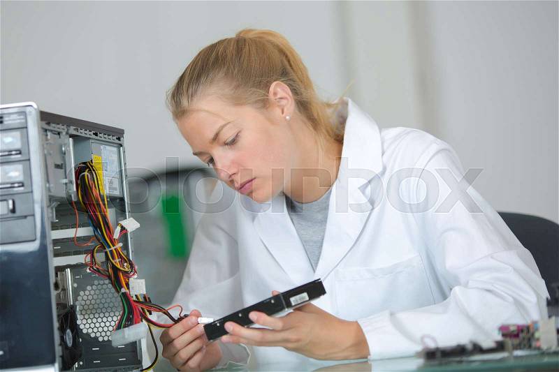 Computer technician fixing a motherboard, stock photo