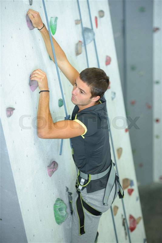 Young man on climbing wall, stock photo