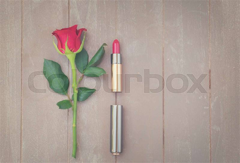 Still life with fresh rose flower and red lipstick, retro toned, stock photo