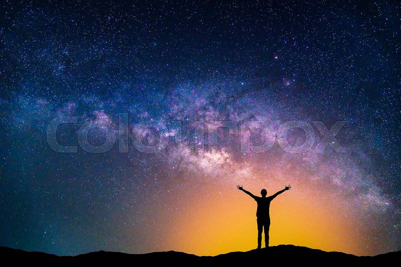 Landscape with Milky way galaxy. Night sky with stars and silhouette happy man on the mountain, stock photo