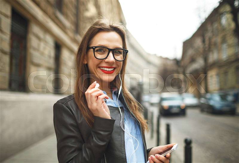 Businesswoman walking down the street while talking on smart phone. Happy smiling caucasian business woman busy, stock photo