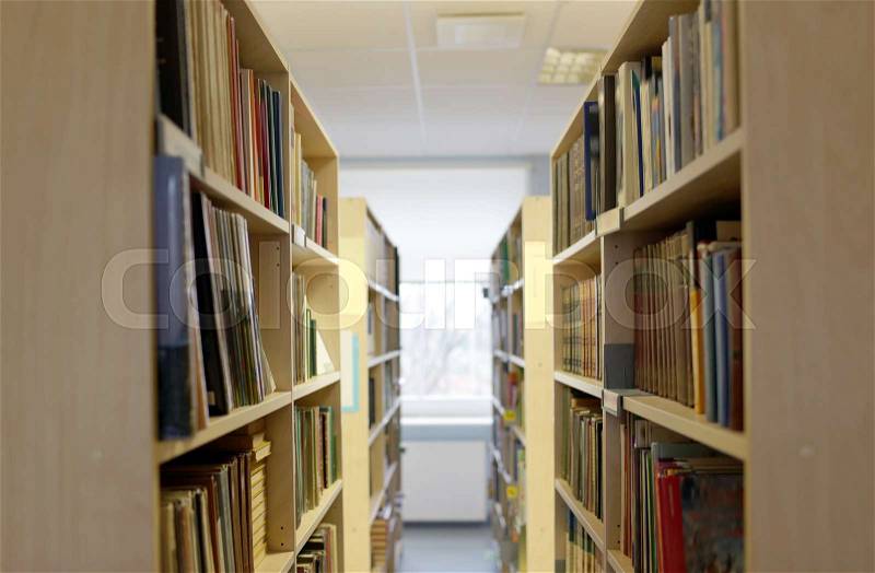 Education, school, literature and knowledge concept - bookshelves with books at public library, stock photo
