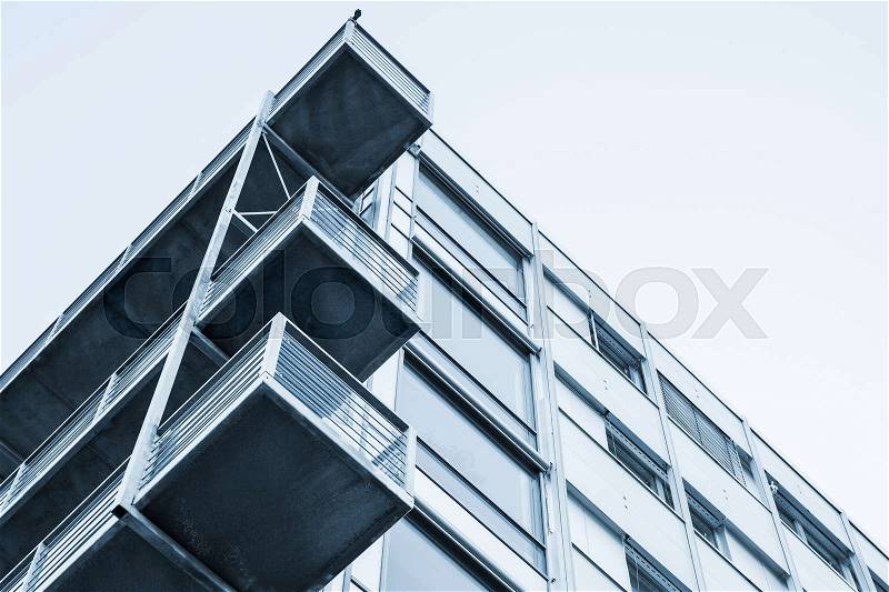Abstract contemporary architecture fragment, walls and balconies made of glass and concrete. Blue tonal correction filter photo effect, stock photo