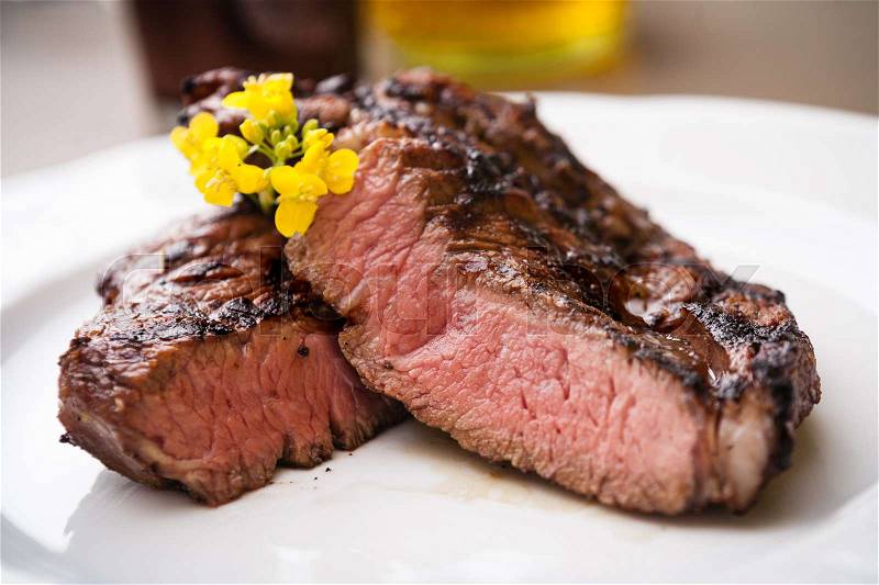 Entrecote with grilled garlic served on a plate, stock photo
