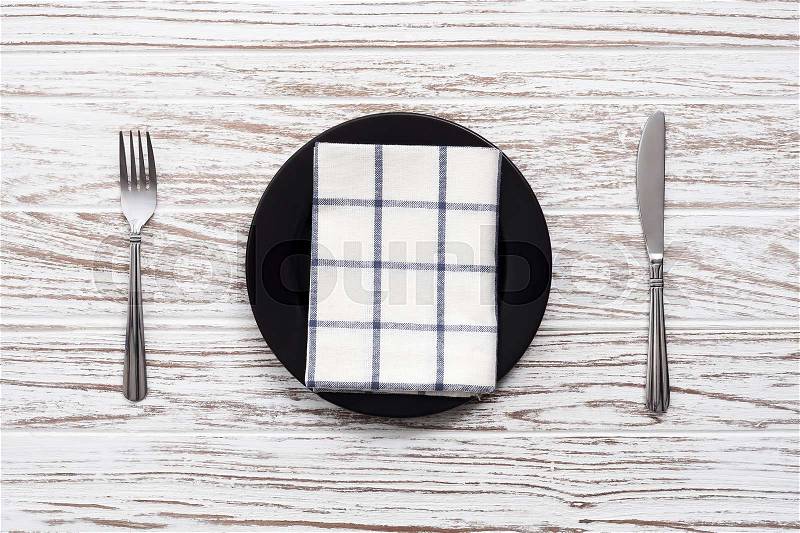 Empty plate napkin fork knife silverware white wooden table background still life vintage flat lay, stock photo