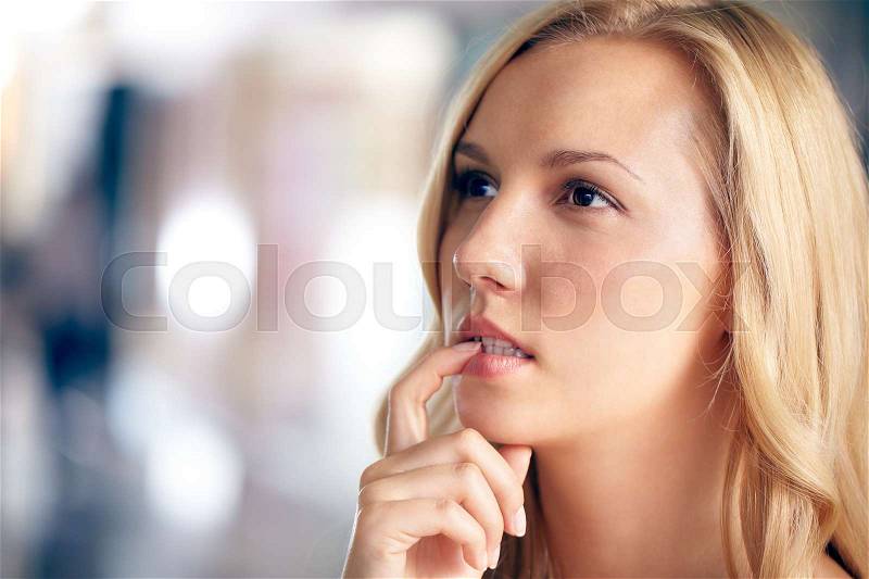 Face of a beautiful woman looking away in doubt, stock photo