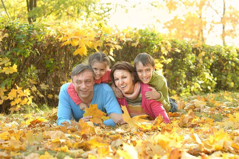 Happy family relaxing in autumn park together, stock photo