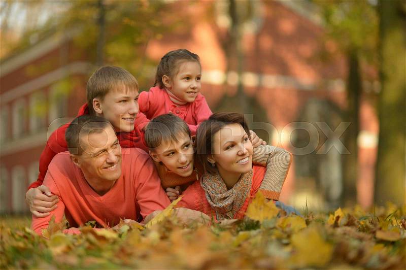 Portrait of a happy family relaxing in autumn park, stock photo