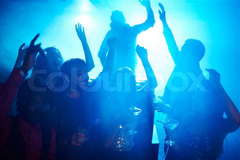 Joyful people with drinks enjoying night party in club, stock photo