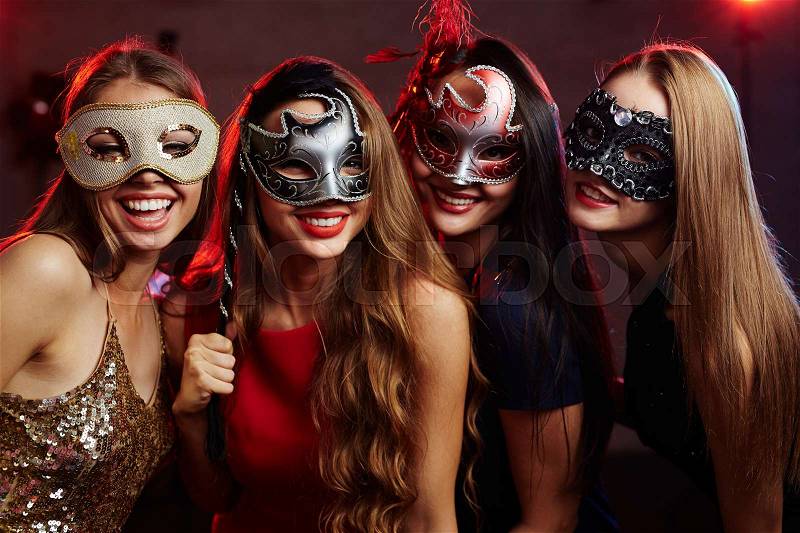 Group of happy girls in masquerade masks having party, stock photo