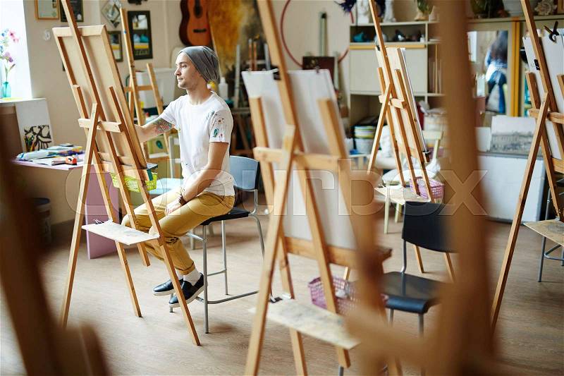 Skilled man learning to paint in art-school, stock photo