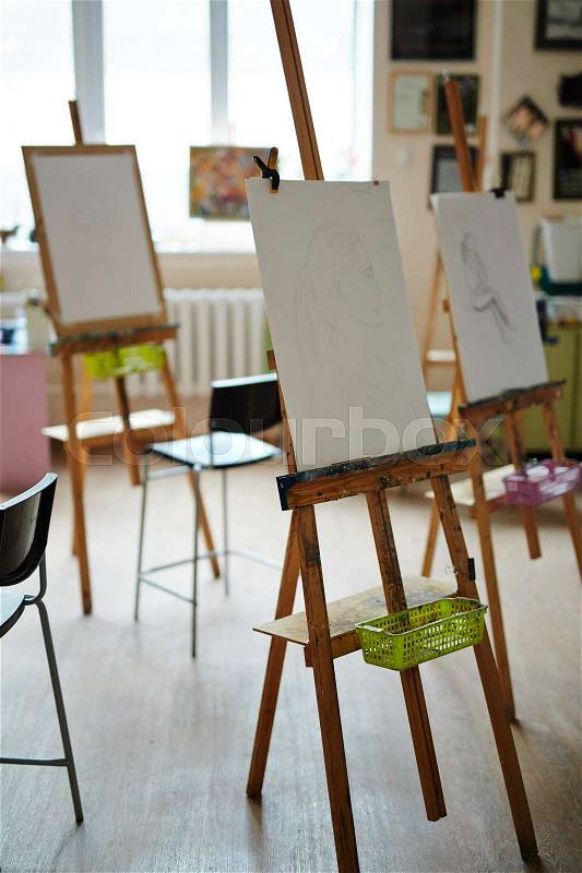 Empty studio of arts with easels and sketches on paper-sheets, stock photo
