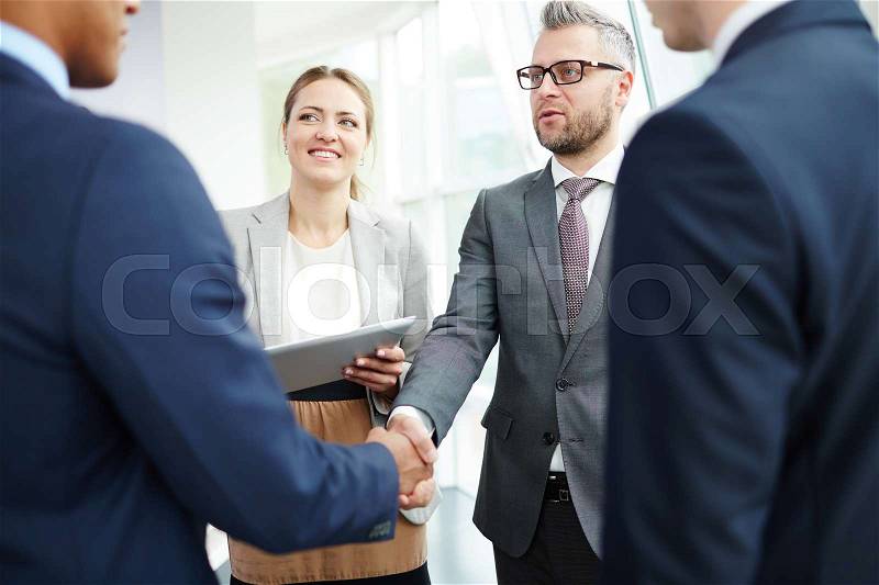 Happy business people striking deal with partner, stock photo