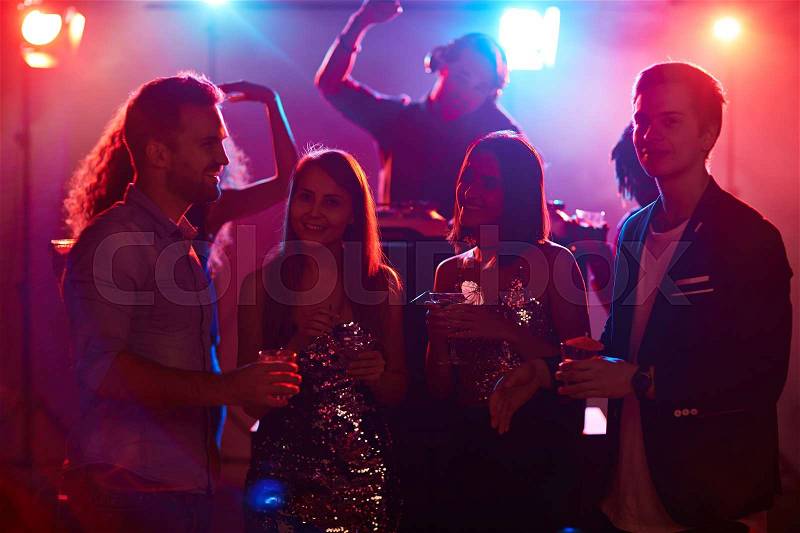 Happy young friends spending evening in night club, stock photo