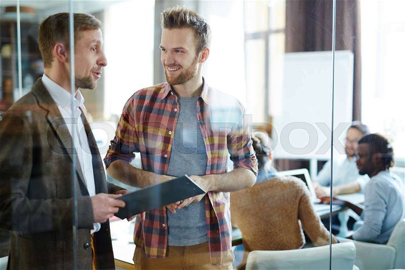 Two financial managers discussing data in working environment, stock photo