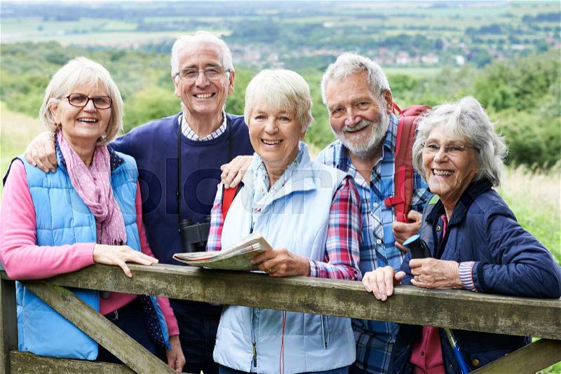 Group Of Senior Friends Hiking In Countryside, stock photo