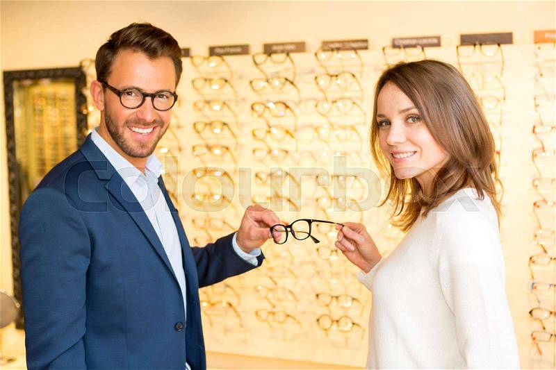 View of a Young attractive woman testing new glasses with optician, stock photo