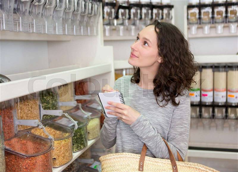 View of a Young attractive woman shooping looses spices at the grocery, stock photo