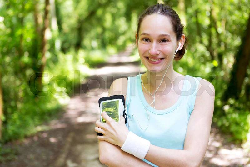 View of a Young attractive woman setting her mobile in armband before running, stock photo