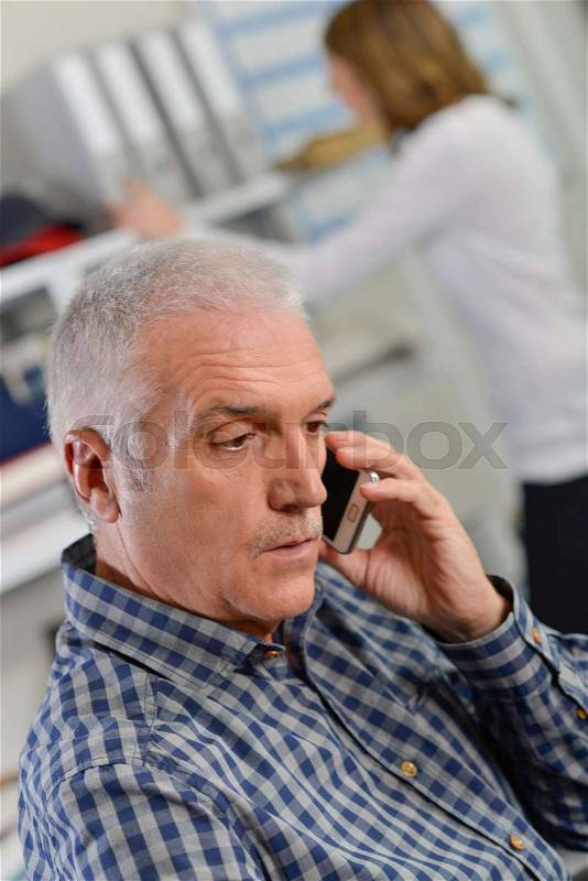 Senior office worker on the phone, stock photo