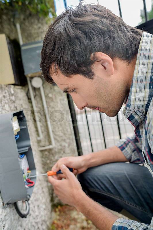 Electrician repairing an intercom system, stock photo