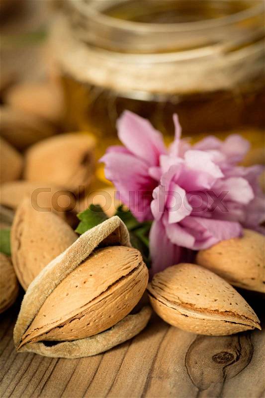 Almond oil and almonds on an old wooden background, selective focus, stock photo