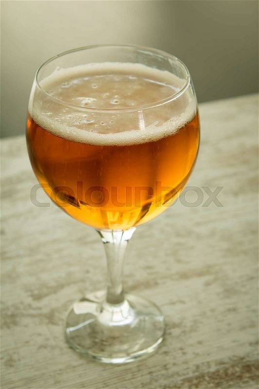 Full lager beer cup on a wooden table, stock photo