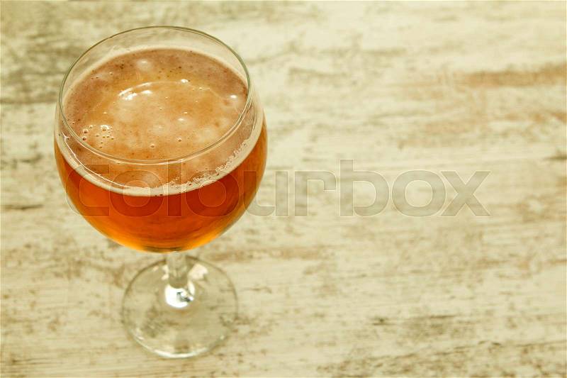 Full lager beer cup on a wooden table, stock photo