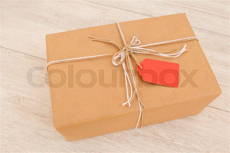Nice gift wrapped with brown paper and decorated with white ribbons and red, stock photo