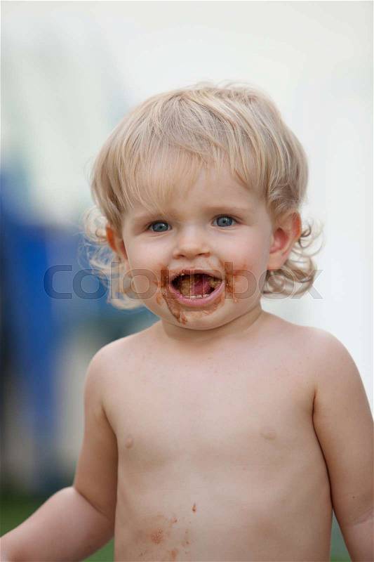 Happy baby with a dirty face after eat chocolate ice, stock photo
