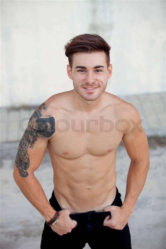 Handsome fit athletic shirtless young man with a tattoo, stock photo